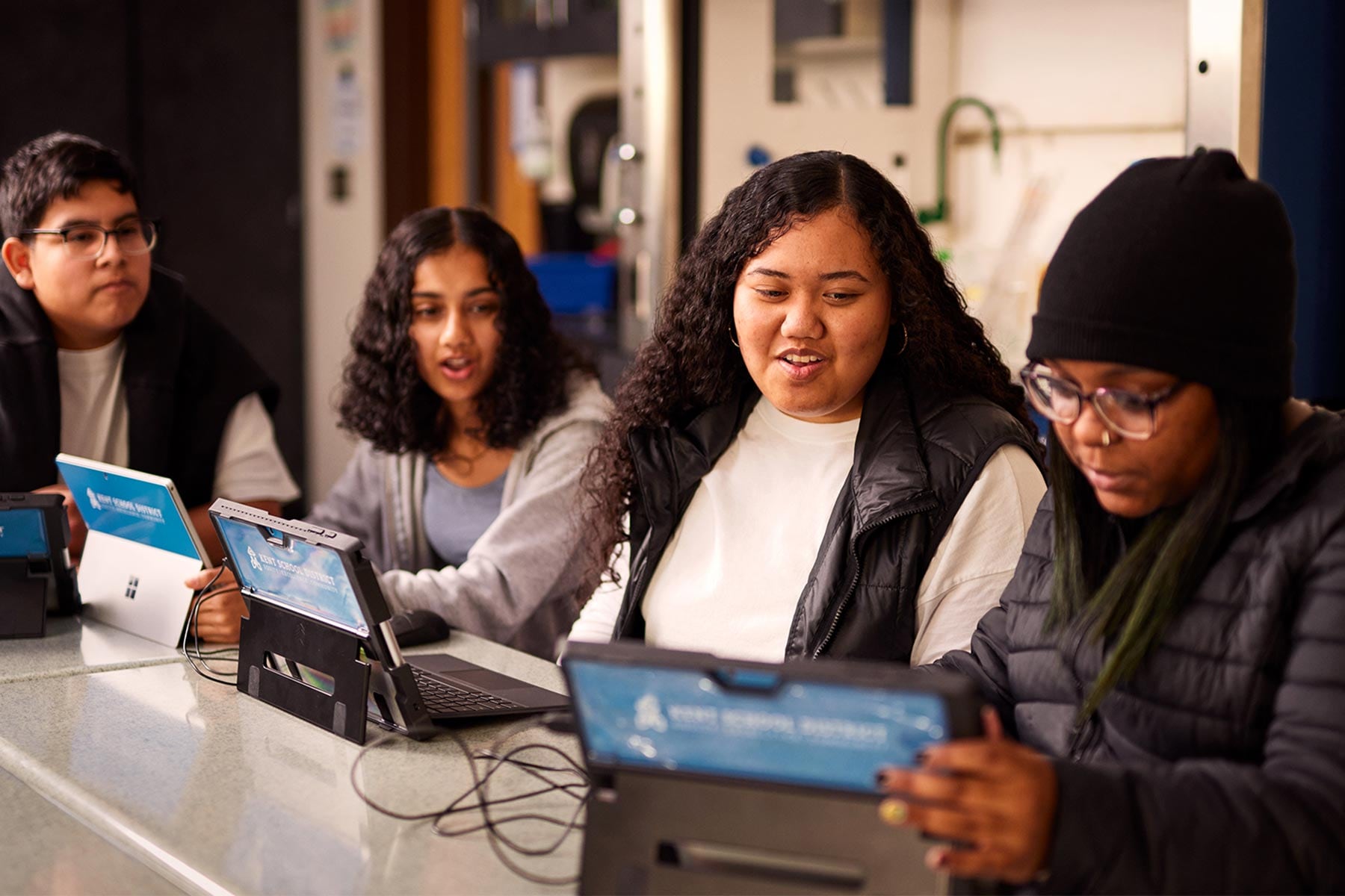 A diverse group of people using laptops in a classroom.